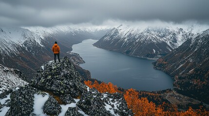 Man overlooking snowy mountain lake vista