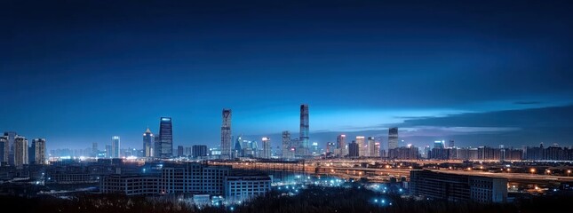 Fototapeta premium Stunning Nightscape of a Modern City Skyline Illuminated by Urban Lights under a Deep Blue Sky
