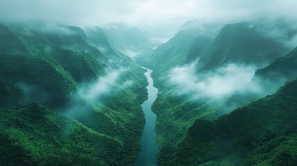 Aerial view of a lush green valley with a winding river and misty mountains in the background