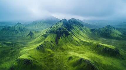 Aerial view of lush green mountains under a cloudy sky, showcasing nature's tranquility and beauty