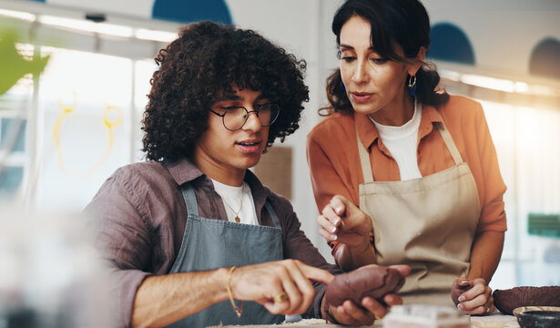 Woman, man and pottery teacher at class, advice and sculpture for art, help and process for results. People, coach and support for creativity, listening and learning with tools in course at workshop - Powered by Adobe