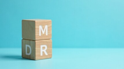 Obraz premium Wooden blocks spelling out MDR on a light blue background showcasing a minimalist concept for marketing, design, or research.