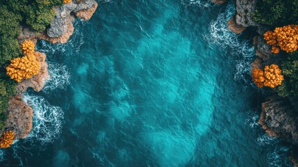 Aerial view of turquoise ocean waves crashing against rocky shores surrounded by lush greenery