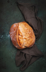 Rustic whole grain wheat sourdough bread. Green table background, top view