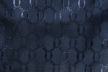 Close-up of a dark navy blue textured fabric with intricate embossed circles.