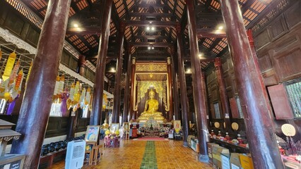 Serene Interior of a Traditional Buddhist Temple with Golden Statue