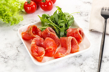 Sliced salmon with fresh arugula