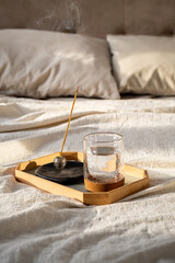 Morning Calm, Smoldering Aromatherapy Incense and Glass of Water on Tray by Bed.