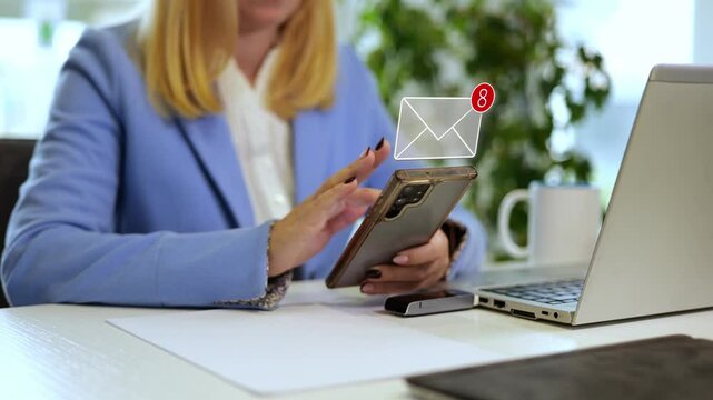Young millennial businesswoman using her phone in an office, receiving messages with animated graphics representing communication