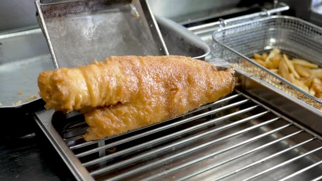 Freshly fried fish fillet served hot from the fryer at a local seafood restaurant in the afternoon