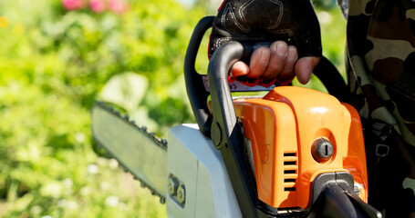 Naklejka premium Man with a chainsaw in the garden