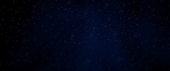 Fototapeta premium A cinematic shot of a stylishly atmospheric background featuring a dense, starlit night sky rendered in deep blues, purples, and blacks, creating a sense of depth and mystery.