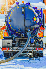 Sewage Tank truck. Sewer pumping machine. Septic truck. Pumping out sewage from a septic tank. Septic tank service. Close-up of a sewer machine with a hose near the house.