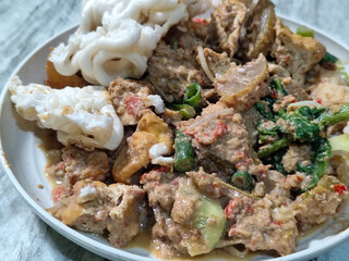 Rujak Cingur. Traditional Javanese food consisting of lontong with vegetables, peanut sauce, petis, tempeh, tofu, beef tongue, and crackers.