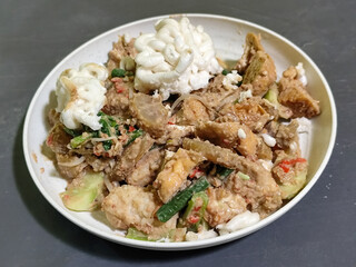 Rujak Cingur. Traditional Javanese food consisting of lontong with vegetables, peanut sauce, petis, tempeh, tofu, beef tongue, and crackers.