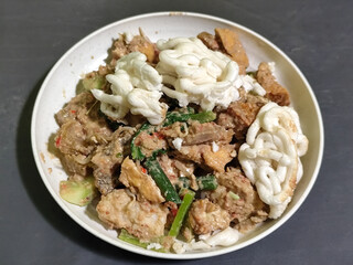 Rujak Cingur. Traditional Javanese food consisting of lontong with vegetables, peanut sauce, petis, tempeh, tofu, beef tongue, and crackers.