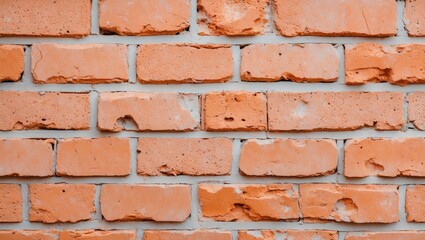 Obraz premium Close-up view of a textured light-orange brick wall showcasing uneven surfaces and natural weathering details