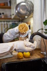 woman washes black kitchen faucet with wooden brush, eco-friendly cleaning