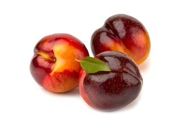 Three ripe peaches with a leaf on top