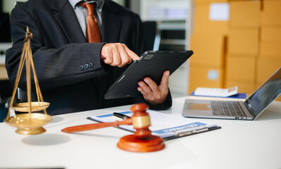 justice and law concept.Male judge in a courtroom  the gavel, working with tablet on table .