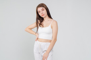 Naklejka premium Young cute brunette girl standing on a white background. Copyspace