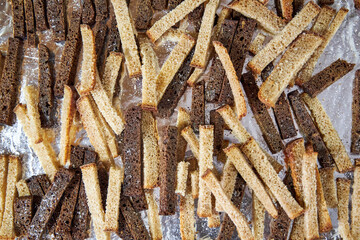 on the tray lay slices of gray and black bread for breadcrumbs