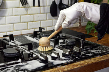 a woman washes a black glass slab with a wooden brush, eco-friendly cleaning