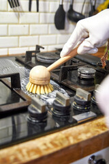 a woman washes a black glass slab with a wooden brush, eco-friendly cleaning