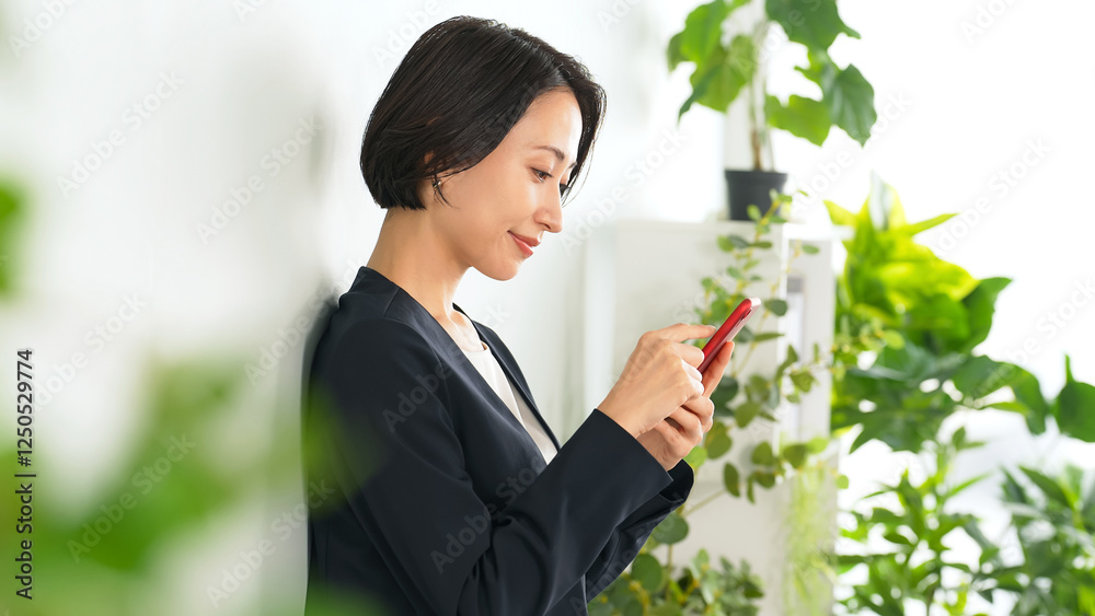 Leinwandbilder スマホ、スマートフォン、女性、ビジネスウーマン、操作、ミドル、日本人、アプリ、SNS、笑顔、楽しい、オフィス、タッチ、メール、ブラウザー、検索、webサイト、予定、スケジュール、インターネット、オンライン、動画、ビジネス、グリーン、爽やか、リラックス、ボタニカル、モバイル、DX、IT、IoT、ゲーム、通信、新緑、仕事、デジタル、データ、マーケティング、副業、電子書籍、電子コミック、サブスク、購読、