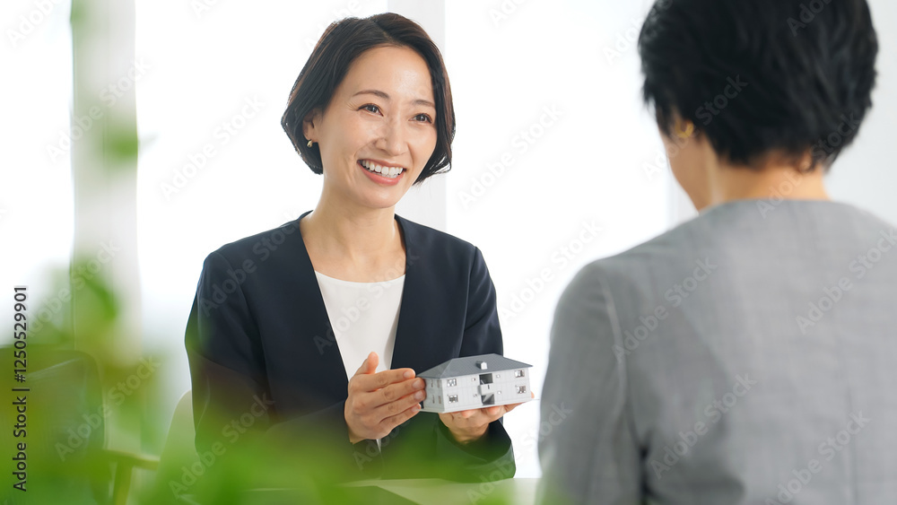 Aufkleber 女性、ビジネス、ビジネスウーマン、ミーティング、打ち合わせ、商談、説明、住宅、提案、接客、不動産、相談、会話、笑顔、日本人、設計、営業、メーカー、模型、マイホーム、販売、取引、モデルハウス、オフィス、おすすめ、事務所、賃貸、新築、リフォーム、設計士、建築士、建築、仕事、働く、アドバイザー、住まい、受付、窓口、ビジネスパーソン、ミドル、スーツ、会議、面談、建物、会社、案内、紹介、マンション、インテリ