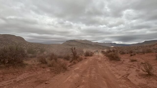 Recreation riding follow off road red desert southern Ut. Off road trail riding in 4x4 all terrain vehicle for sport and recreation. Desert landscape, dusty trails and recreation areas. Southwest Utah