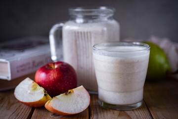 Smoothie with apple, pear and banana. Vegetarian breakfast. Fruit smoothie in a glass on a wooden table. Close-up