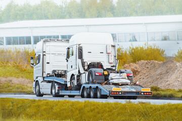 Highway tow truck loaded with commercial trucks and vans
