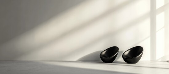 Stylish minimalist black furniture placement on a blank wall creating a serene ambiance with ample space for text integration.