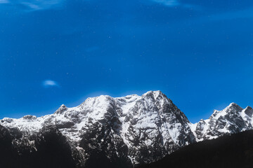 Snow-covered peaks beneath starry sky