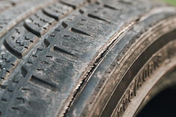 Worn-out vehicle tire displaying surface cracks