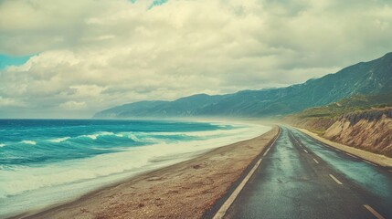 Obraz premium A scenic coastal road bordered by waves and mountains under a cloudy sky, inviting exploration and adventure.