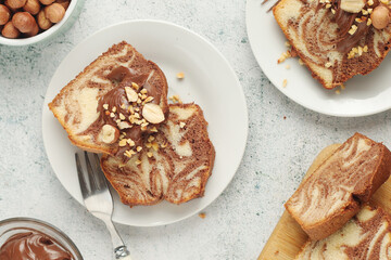 A piece of marble biscuit with chocolate cream and nuts