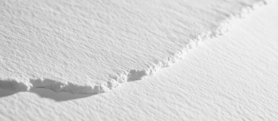 Obraz premium Textured white paper surface with a torn edge showcasing subtle shadows and fine detail for artistic or design applications.