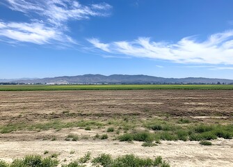 Obraz premium Photo of an empty field. Flat landscape with dirt field and blue sky background,