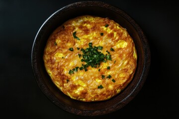 Wooden bowl of cooked egg dish on black background