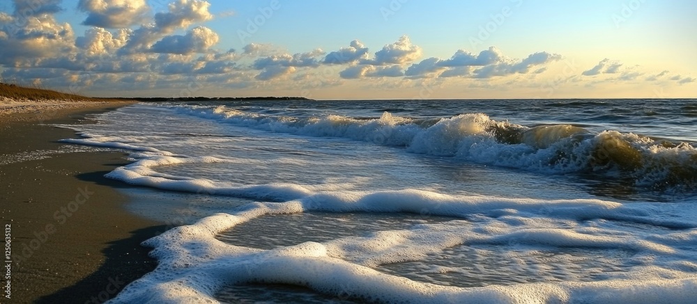 Poster tranquil beach scene at sunset with gentle waves and sea foam creating a serene coastal atmosphere.