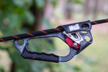 A crossing for sports tourism in the park: a rope is stretched between trees, with carabiners, a...