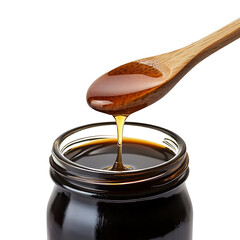 Sweet molasses dripping from a wooden spoon into a jar.