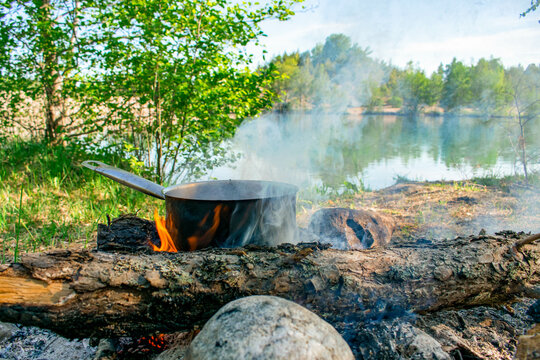 Cooking pot over campfire in Swedish nature by the lake