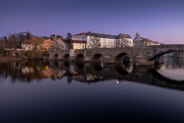 Royal city of Písek. Evening photo of the city. Bridge over the Otava River. Sunset. Quiet evening by the water. Beautiful photo.