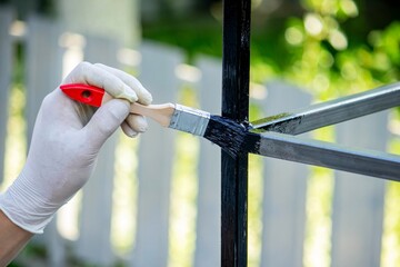 close up of painting metal with brush in garden.