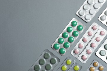 Pills in blister packs on gray  background, close up