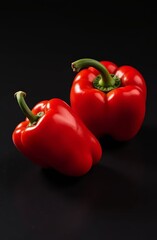 Homemade products from your own garden - red sweet bell pepper on a black background with side lighting. Vertical concept of healthy eating, preparing salads and other food