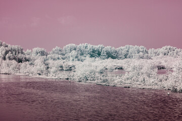 Infrared photography, a body of water reflecting a landscape filled with vegetation
